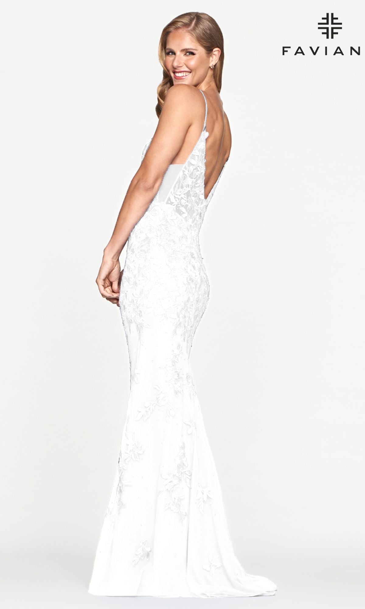 Woman in a fitted white Sheer-Sides Long Lace Prom Dress by Faviana, featuring a deep V-back, stands sideways and smiles. The